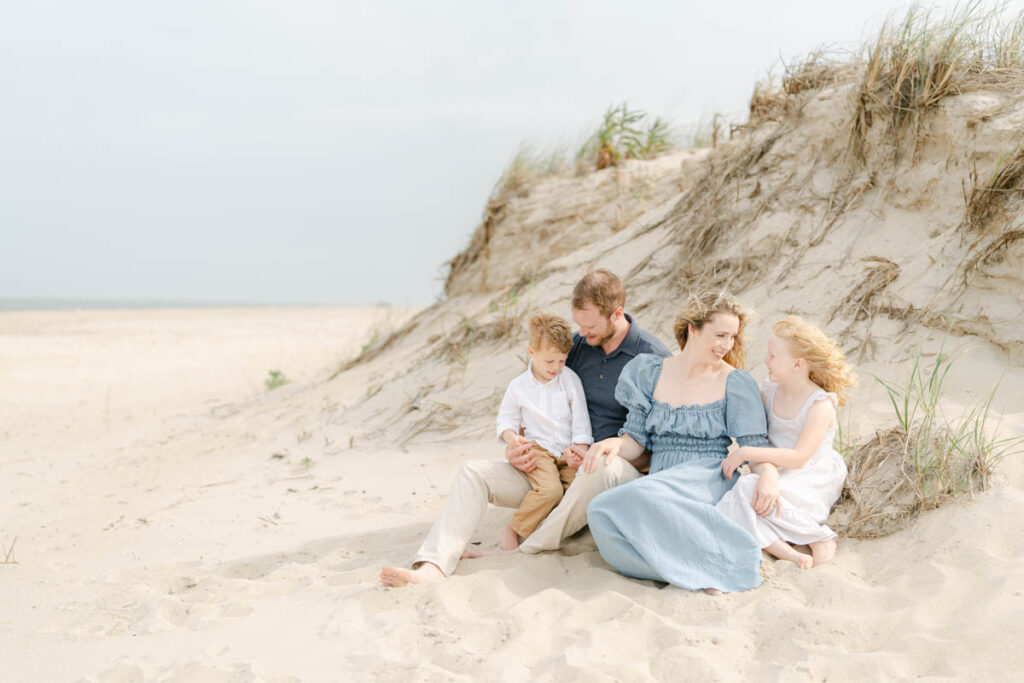 Family of four sits by the dunes near Bethany Beach Delaware