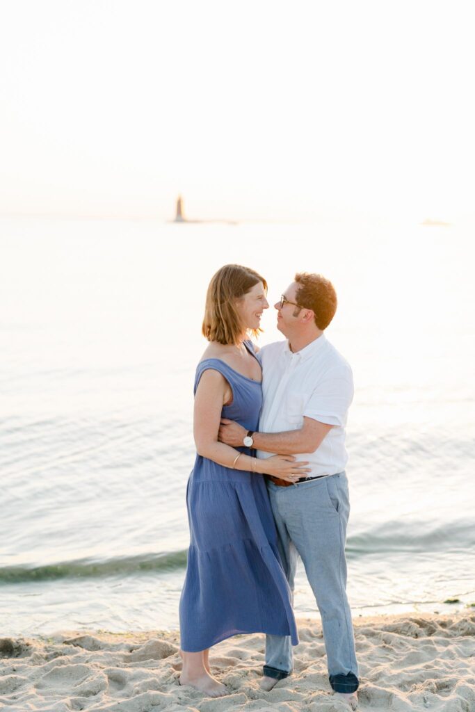 couple pose in front of The Point at sunset in cape henlopen state park