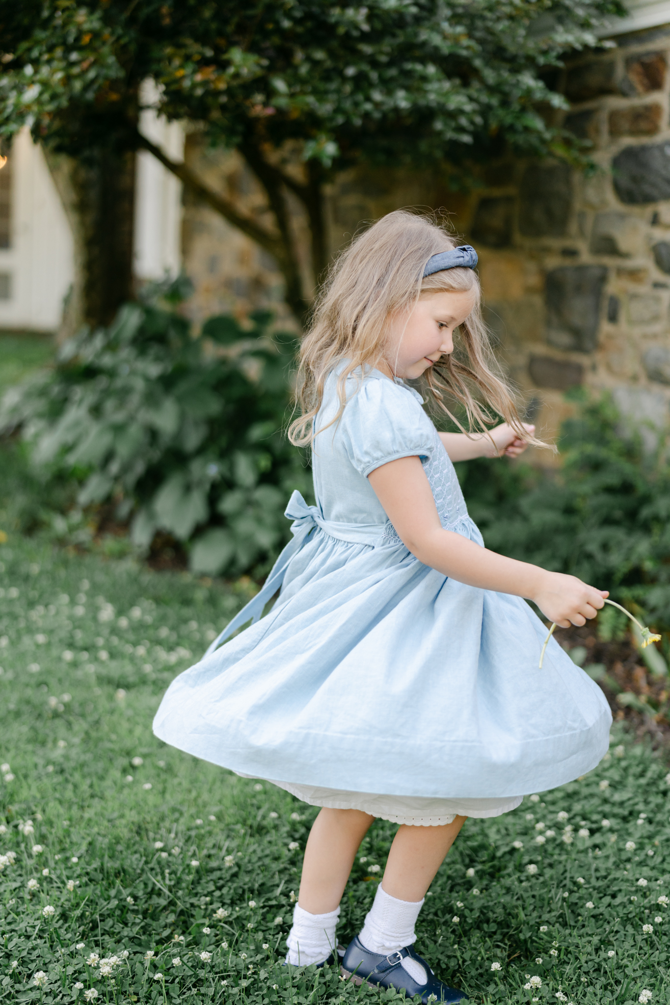 Little girl in blue dress twirling around