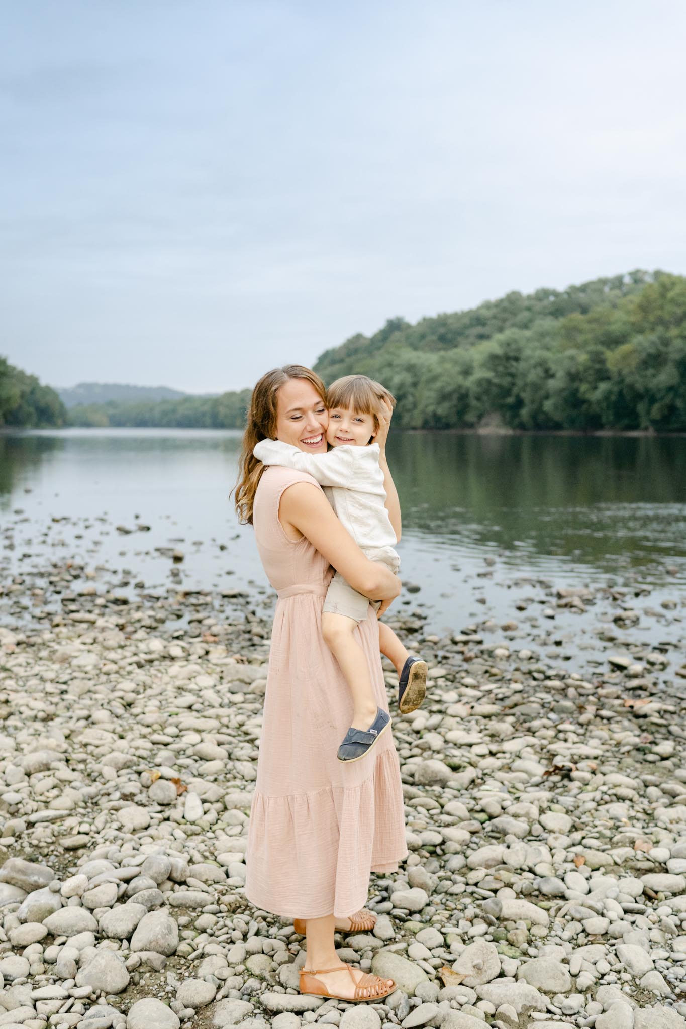 mom in neutral colors holding her child by a lake Parks in Chester County PA