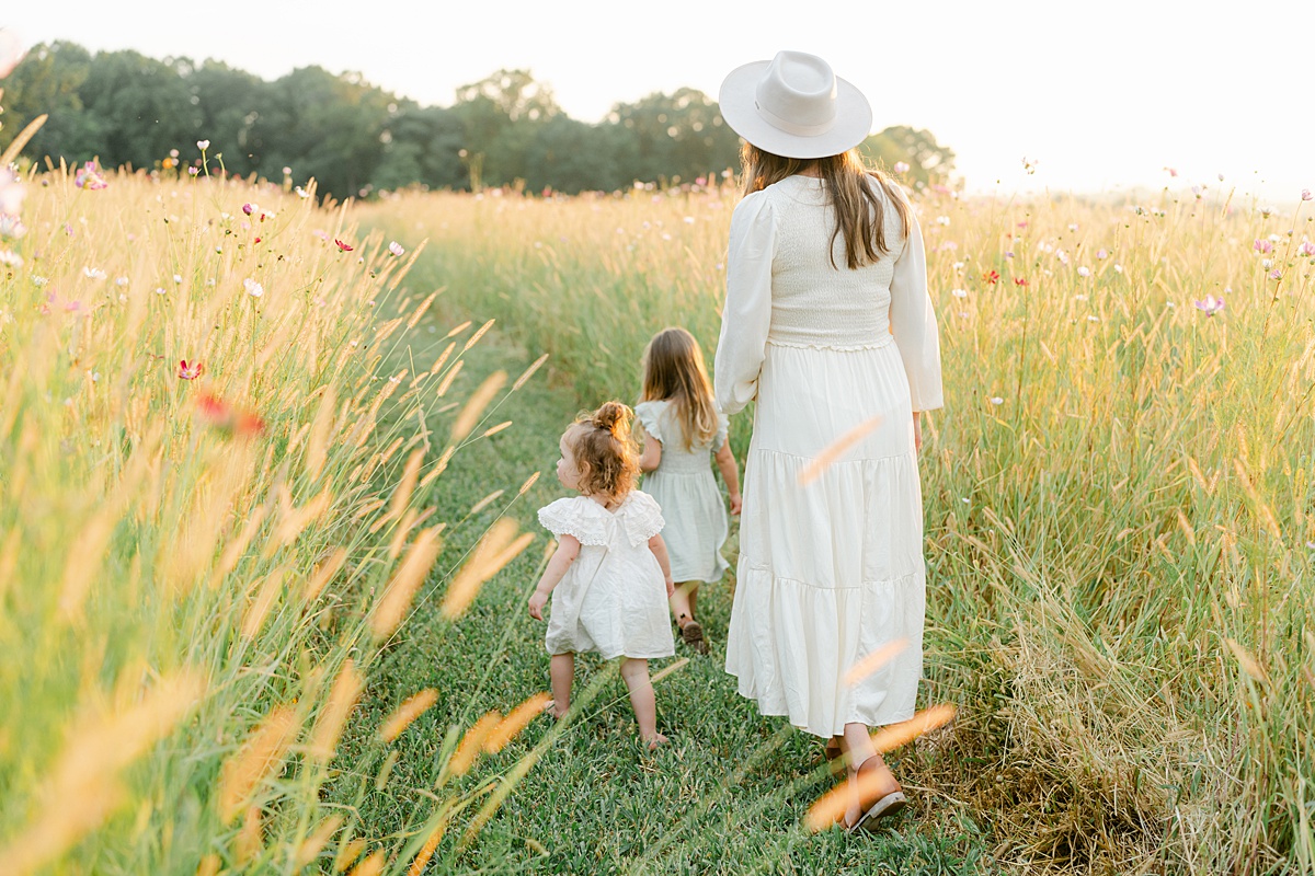 mother and daughters strolling through wildflower field by Philadelphia Maternity Photographer, AnneMarie Hamant