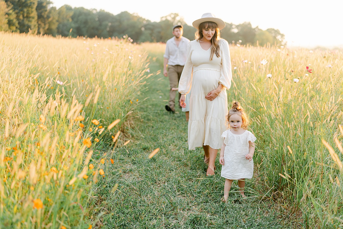 family strolling through wildflower field by Philadelphia Maternity Photographer, AnneMarie Hamant