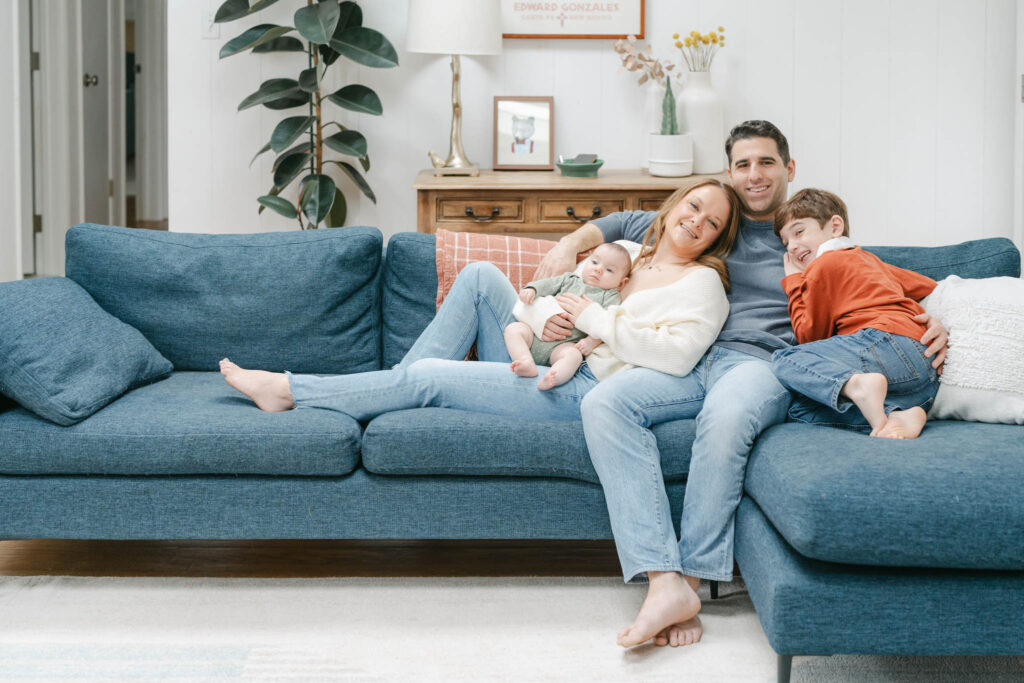  family of four poses on the couch during Wilmington DE newborn session