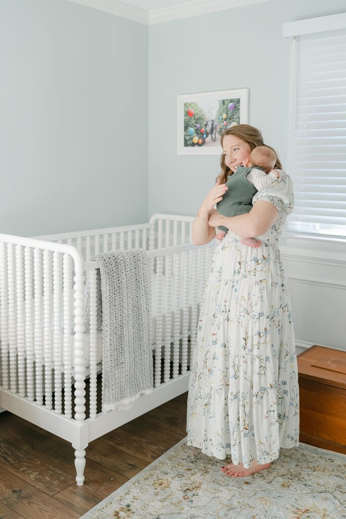Mom holding baby on her shoulder in his nursery by Philadelphia Baby Photographer, AnneMarie Hamant