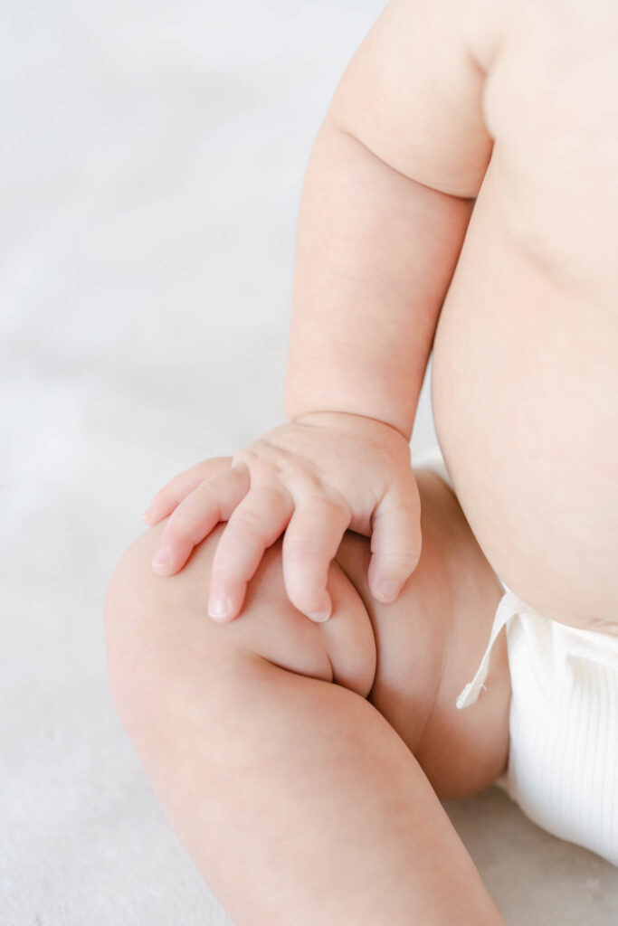 baby hands and rolls on a light backdrop