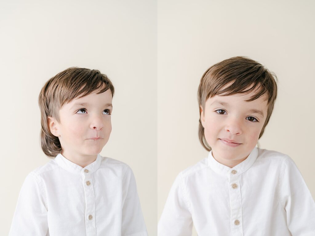 Toddler boy smiling and making funny faces at the camera in front of a beige backdrop.