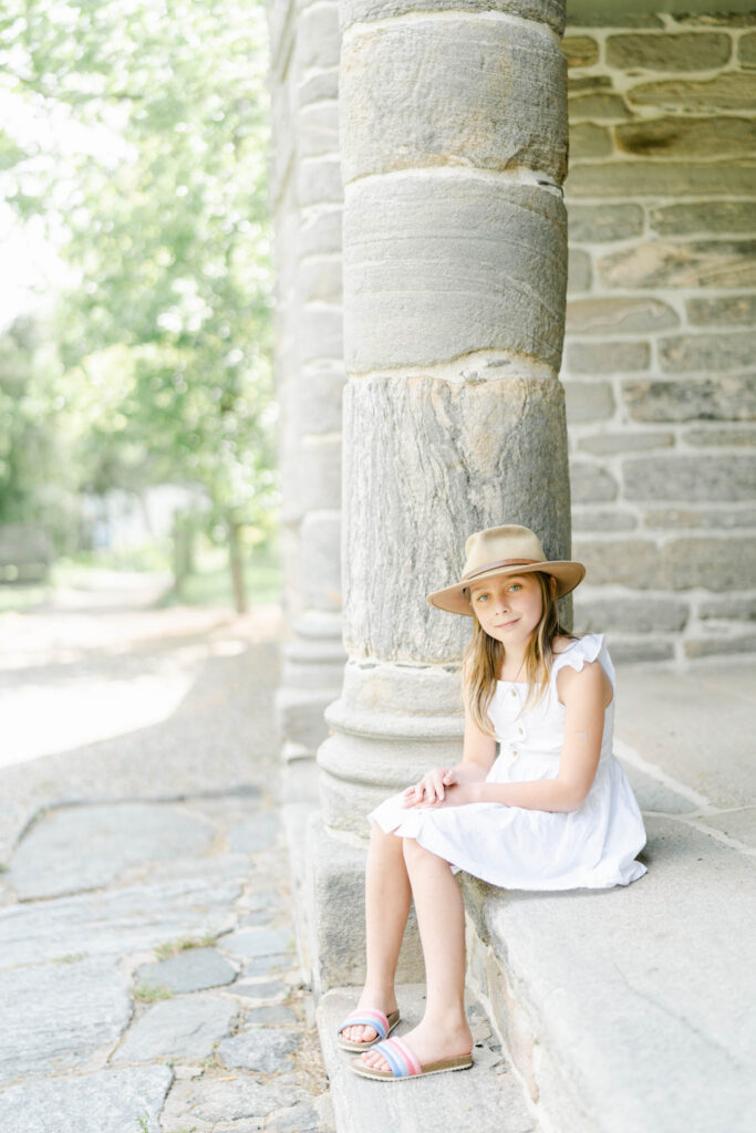 Girl in white dress sits on steps of the mansion at Bartram Gardens outside of Philadelphia, PA