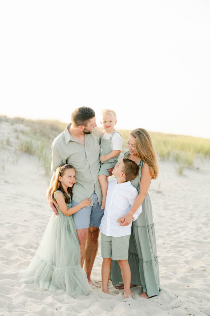 family poses for photos on the beach