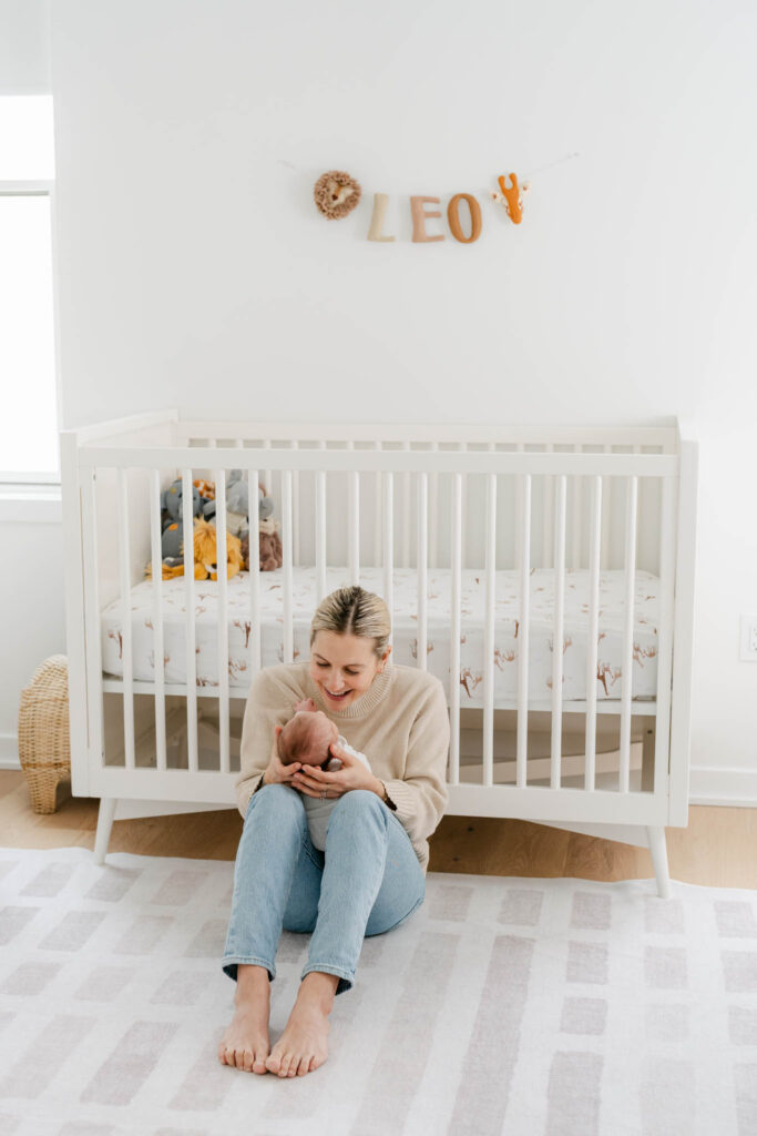 Mom rocks baby in front of crib in philly home